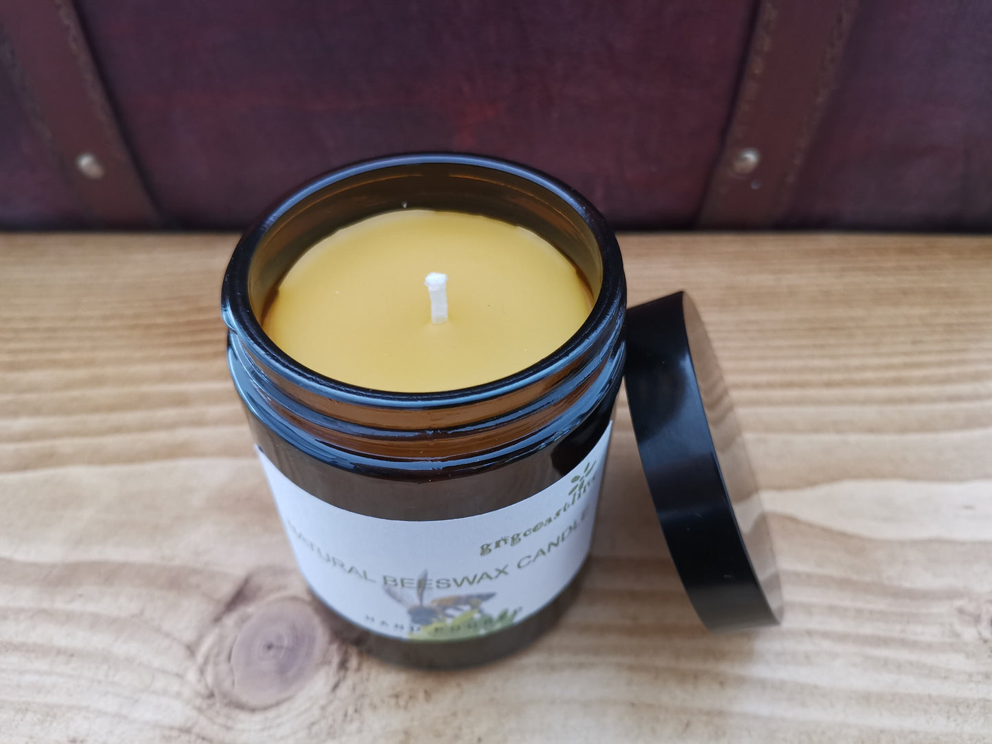 Beeswax Candle In An Brown Glass Jar With Black Lid